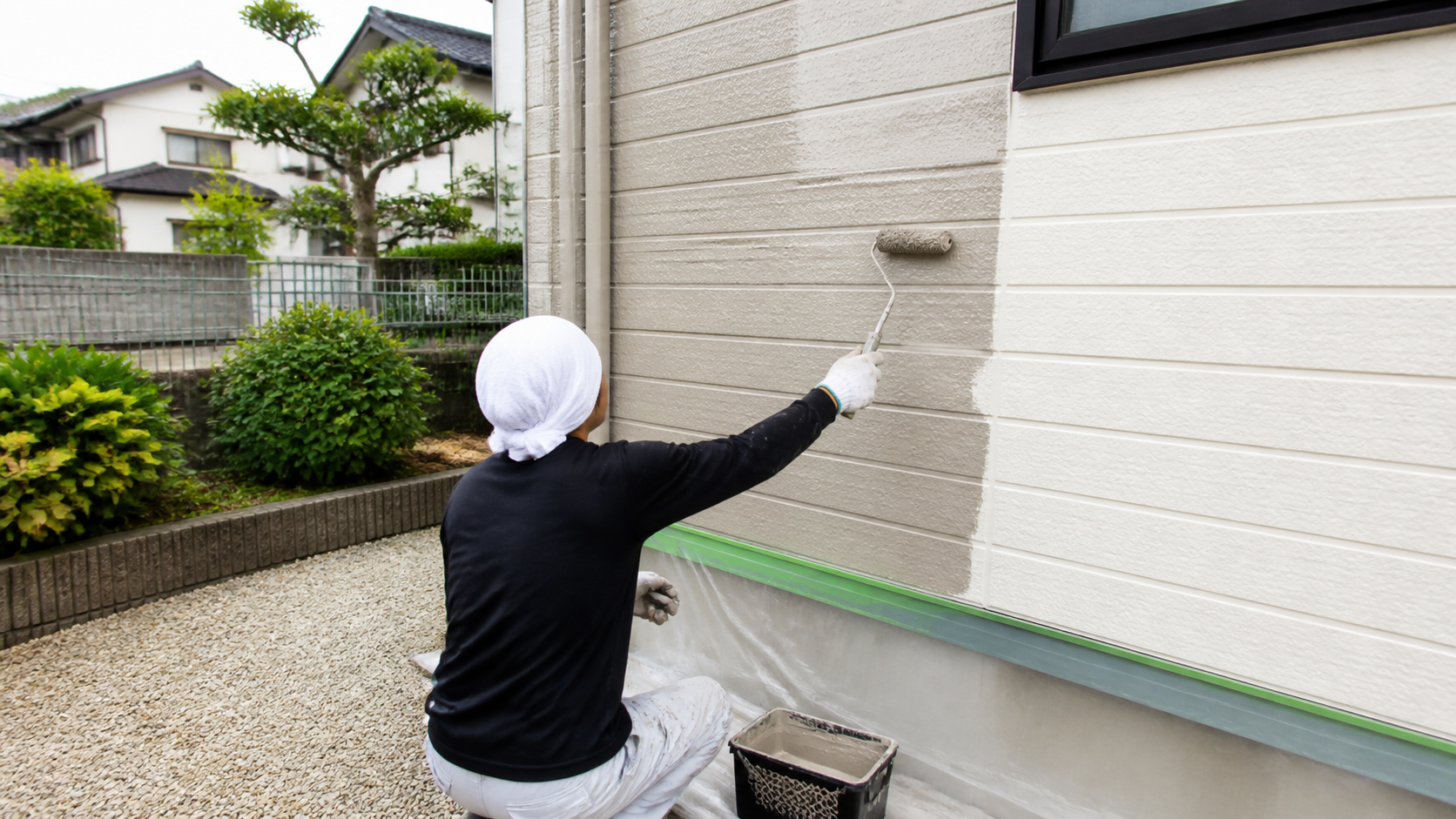 戸建て住宅の外壁をローラーで塗装する作業（イメージ）
