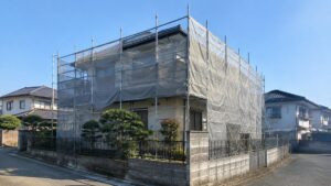足場とメッシュシートで囲まれた2階建て住宅の外観（外壁塗装の工期のイメージ）